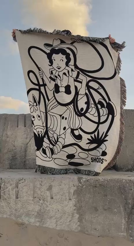 The Cowgirl woven throw blowing in the wind by the sea