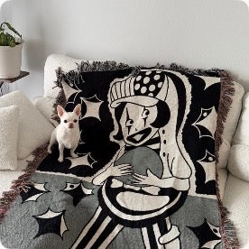Bowling clown woven blanket on a cream sofa with a little chihuahua